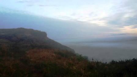 Cloud summit rising out of a mist-covered Cheshire Plain