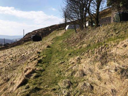 Grassy path beneath a farmhouse