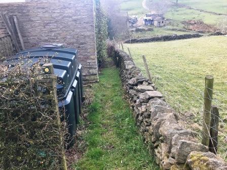 Public footpath down a narrow passageway behind a farmhouse