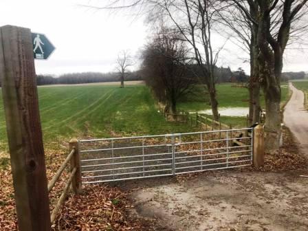 The footpath heads off down the farm road on the right of the picture