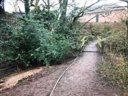 Path crosses a stream before emerging onto another residential road