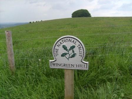 National Trust sign, with the copse at the summit behind