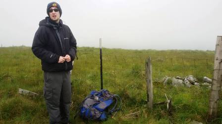 Jimmy at the summit - marked by the small cairn on the other side of the fence